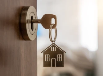 porte clé maison accroché à une paire de clé d'une maison