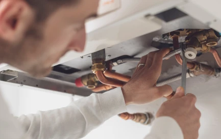 homme qui répare un chauffe eau thermodynamique à cause de son bruit