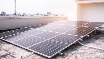panneau solaire sur un toit gris devant un mur blanc