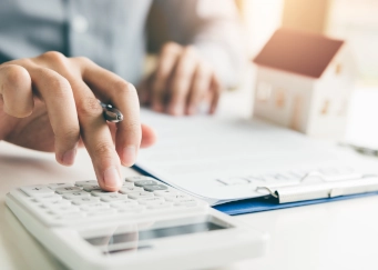 dpe sur des dossier et une femme qui écrit tout en utilisant une calculatrice