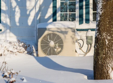 unité extérieure d'une pompe à chaleur dans la neige